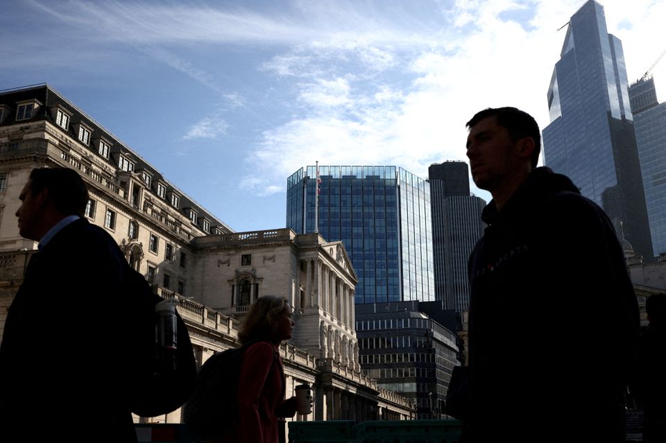 People walk outside the Bank of England in the City of London financial district in London, Britain May 11, 2023