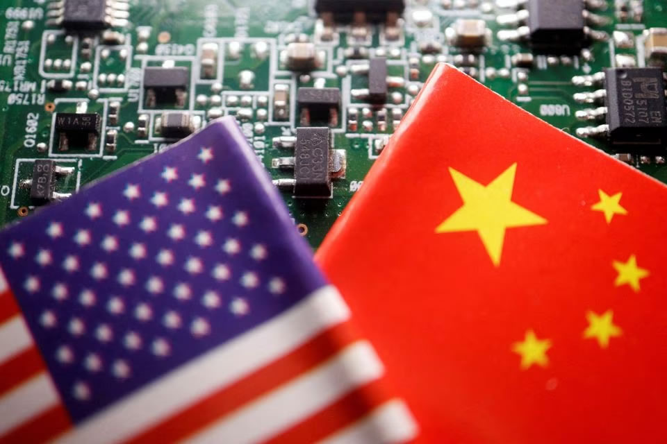 Flags of China and U.S. are displayed on a printed circuit board with semiconductor chips, in this illustration picture taken February 17, 2023. REUTERS/Florence Lo/Illustration/File Photo