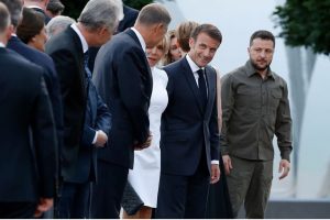 France's President Emmanuel Macron reacts next to Ukraine's President Volodymyr Zelenskiy as they prepare to pose for a group photo ahead of the social dinner during the NATO summit, at the Presidential Palace in Vilnius, Lithuania on July 11, 2023