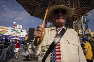 People wait in line ahead of the 2023 Nathan's Famous Fourth of July hot dog eating contest in the Coney Island section of the Brooklyn borough of New York, Tuesday, July 4, 2023.