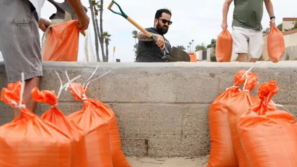 Residents fill up sand bags to help fortify their homes in Seal Beach, California