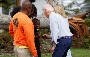 U.S. President Joe Biden shakes hands with a child, next to first lady Jill Biden, during their tour of Hurricane Idalia storm destruction, Live Oak, Florida, U.S., September 2, 2023